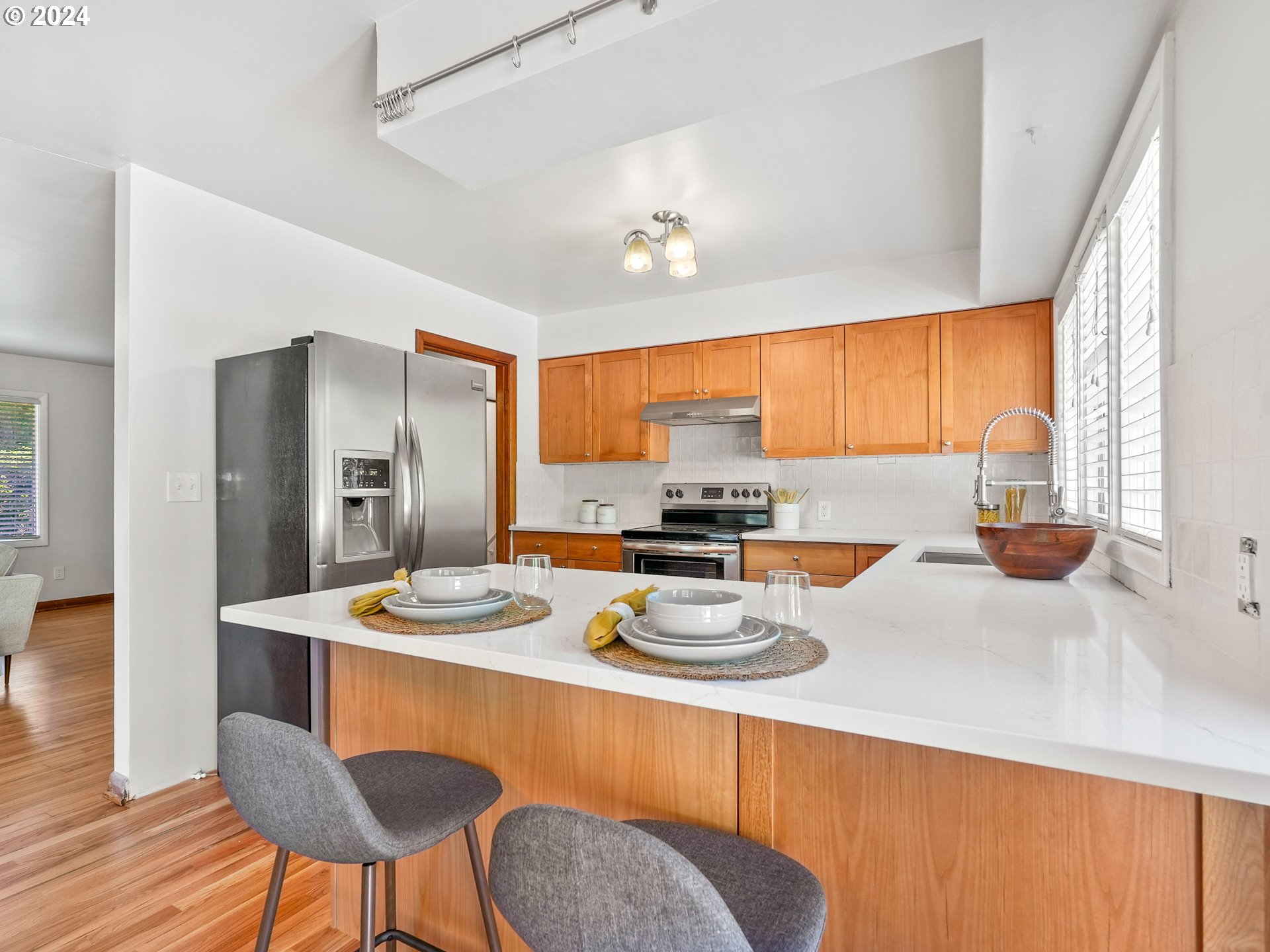5525 Southwest Florida Street Portland, OR 97219 - Photo 13 of 44 a kitchen with stainless steel appliances granite countertop a sink a stove a refrigerator with a dining table and chairs