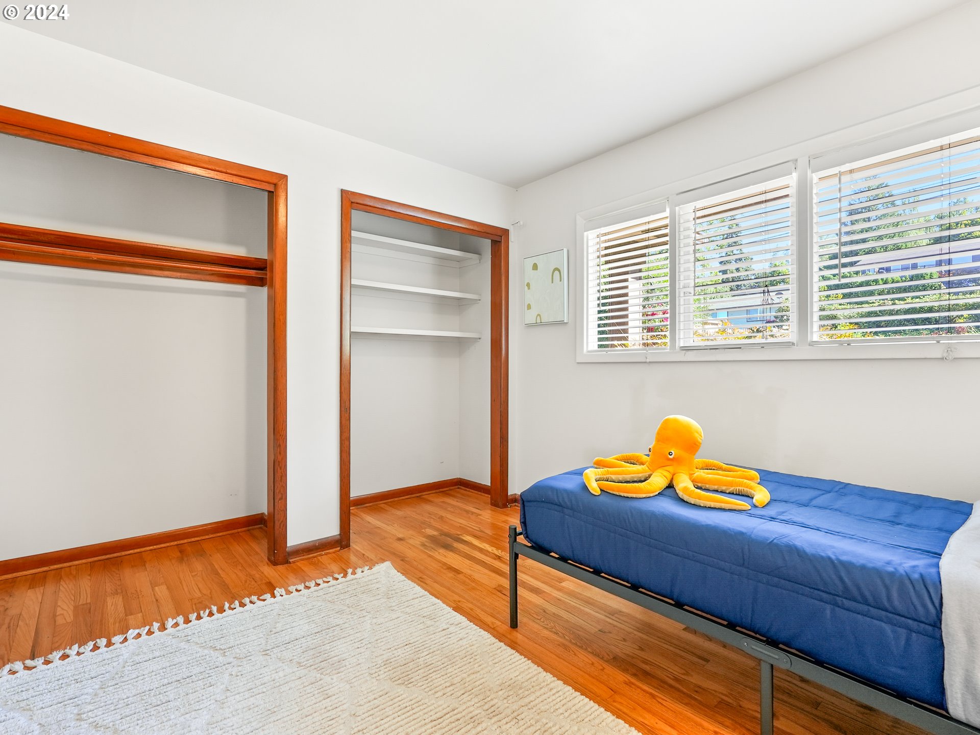 5525 Southwest Florida Street Portland, OR 97219 - Photo 23 of 44 a blue bed sitting in a room next to a window