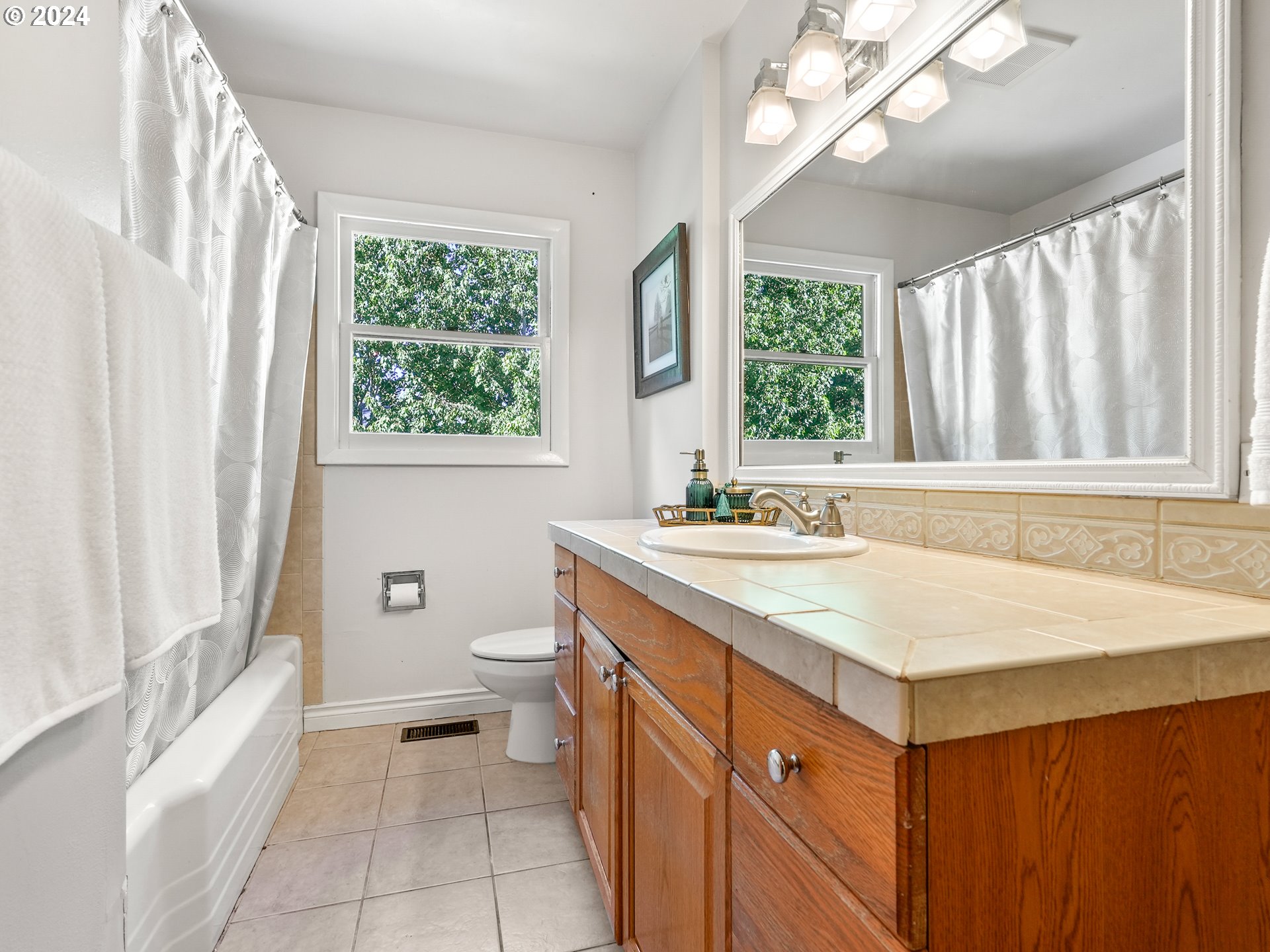 5525 Southwest Florida Street Portland, OR 97219 - Photo 24 of 44 a bathroom with a sink a toilet a mirror and a tub