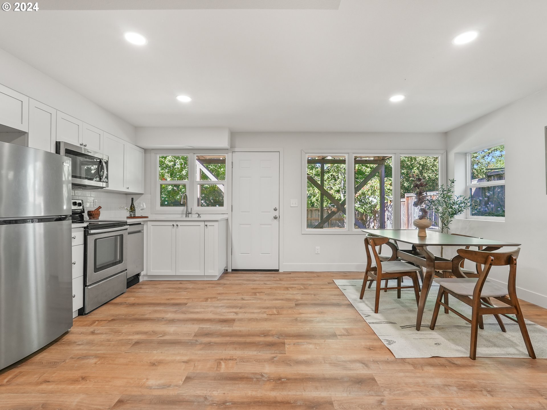 5525 Southwest Florida Street Portland, OR 97219 - Photo 28 of 44 a kitchen with granite countertop a stove a sink dishwasher a refrigerator with a dining table and chairs
