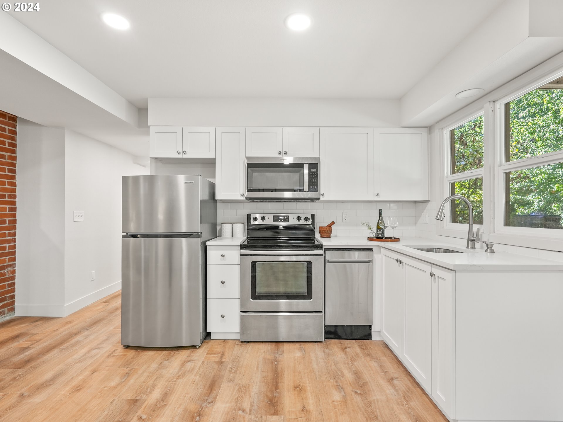 5525 Southwest Florida Street Portland, OR 97219 - Photo 31 of 44 a kitchen with a sink a microwave a refrigerator and cabinets