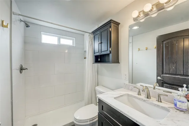 a bathroom with a sink toilet vanity and shower