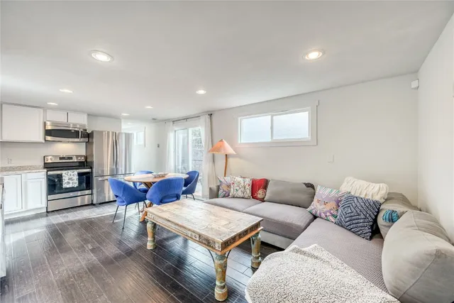 a living room with furniture and kitchen view