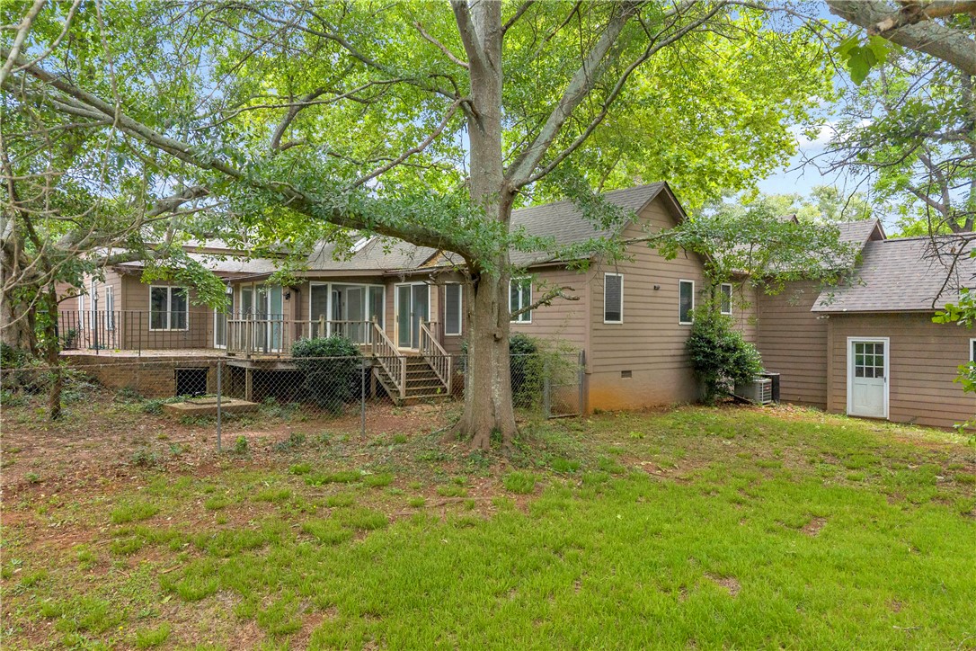 200 Chenault Road Townville, SC 29689 - Photo 27 of 47 Mature trees shade a spacious back deck and fenced yard, perfect for outdoor enjoyment.