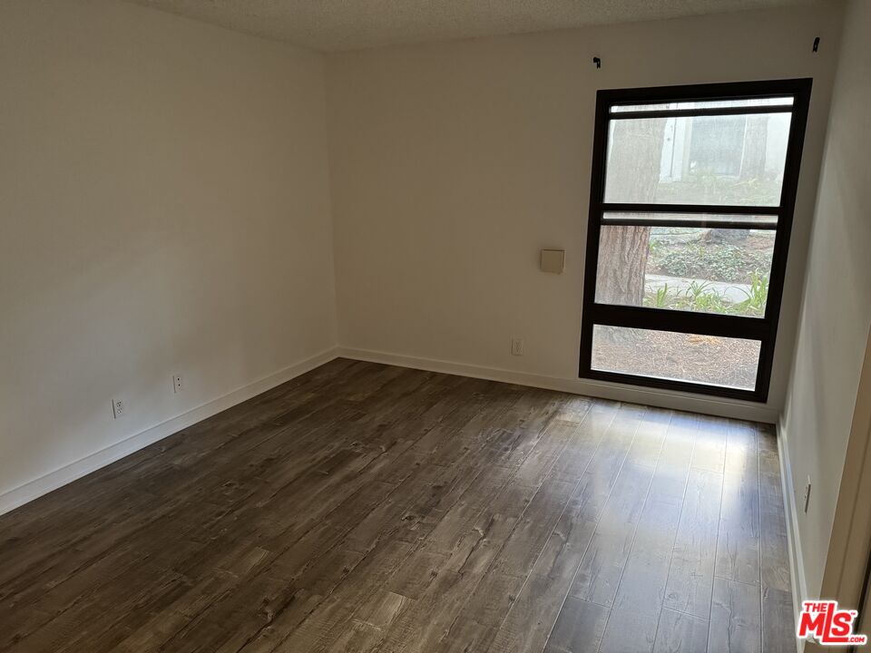 8640 Gulana Avenue, Unit K1020 Playa del Rey, CA 90293 - Photo 11 of 35 an empty room with wooden floor and mirror