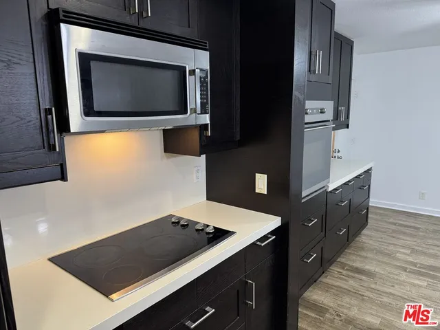 a living room with stainless steel appliances kitchen island granite countertop furniture and a large window