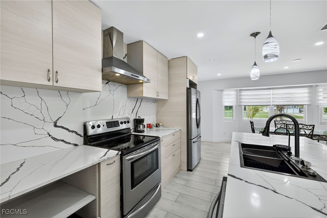 1672 Many Road North Fort Myers, FL 33903 - Photo 11 of 50 a kitchen with stainless steel appliances a stove a sink and a refrigerator
