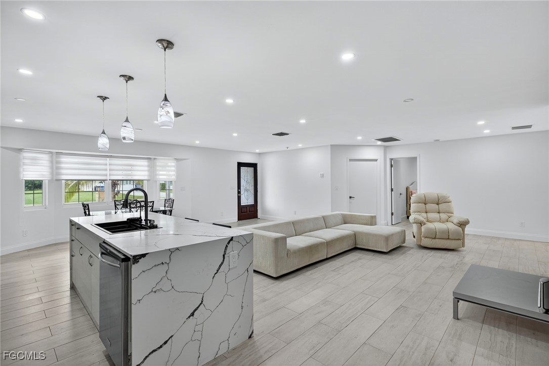 1672 Many Road North Fort Myers, FL 33903 - Photo 13 of 50 a kitchen with living room and white cabinets