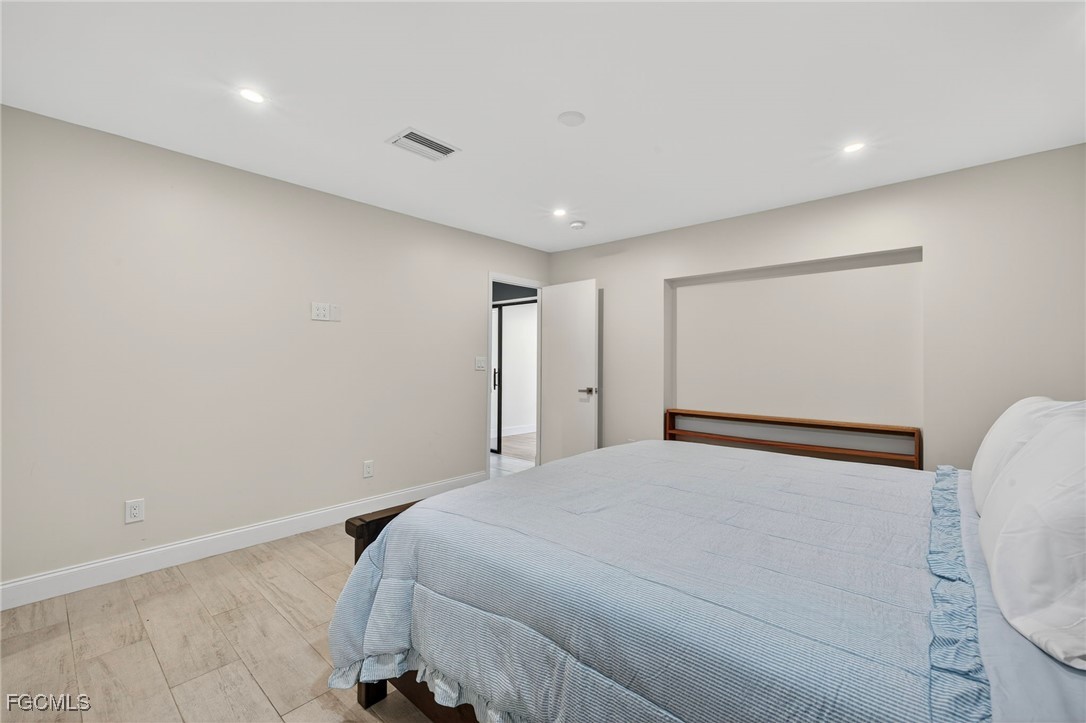 1672 Many Road North Fort Myers, FL 33903 - Photo 18 of 50 a bedroom with a bed and a mirror