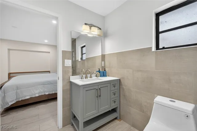 a bathroom with a double vanity sink toilet and mirror