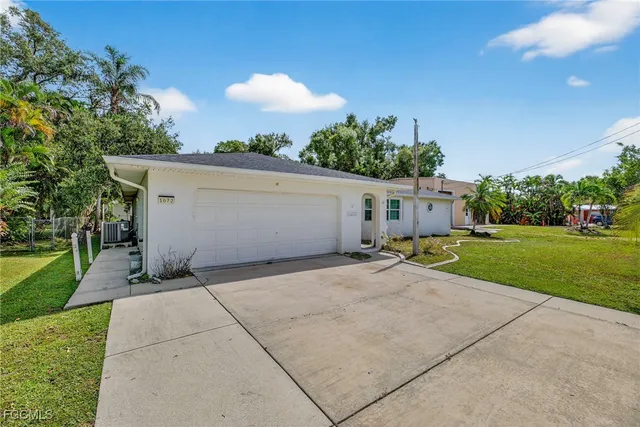 a view of a house with a yard and garage