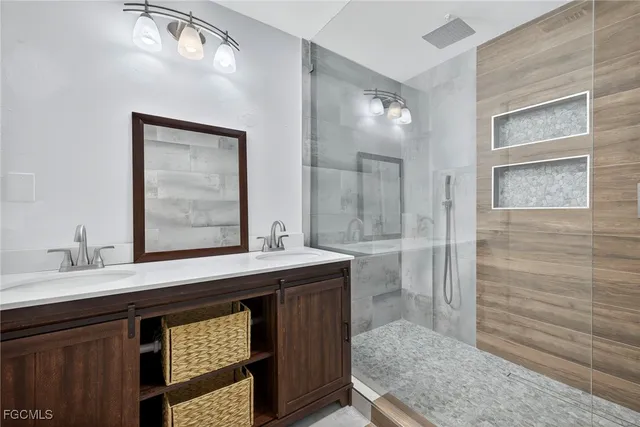 a en suite bathroom with a granite countertop sink and a mirror