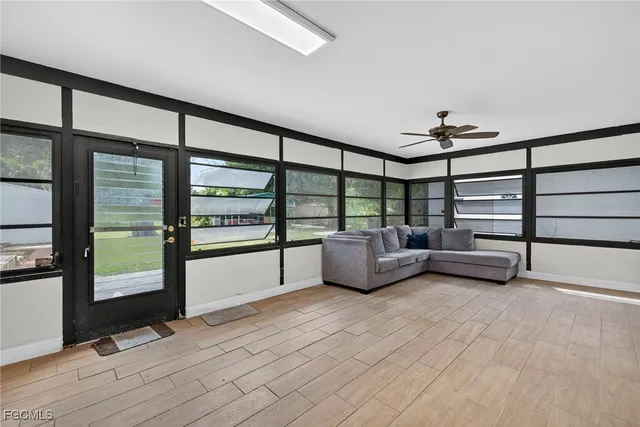 a view of an empty room with furniture wooden floor and windows