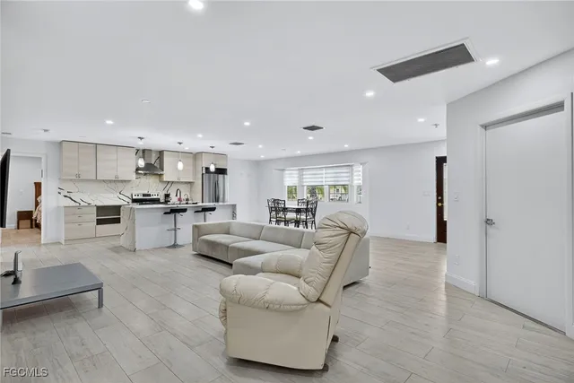 a living room with furniture and kitchen view