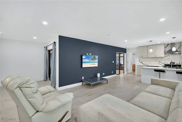 a living room with furniture and view of kitchen
