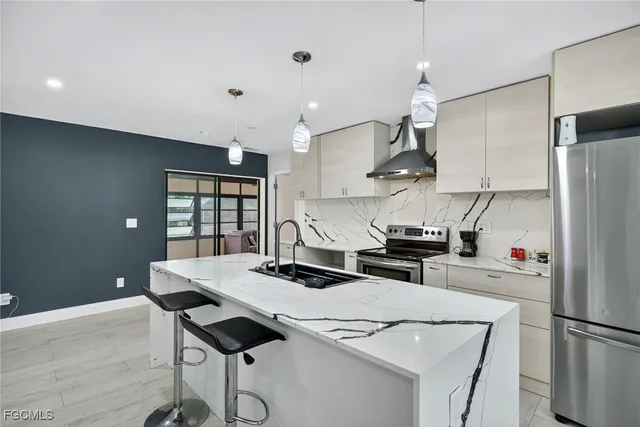 a kitchen with stainless steel appliances kitchen island a table and chairs in it