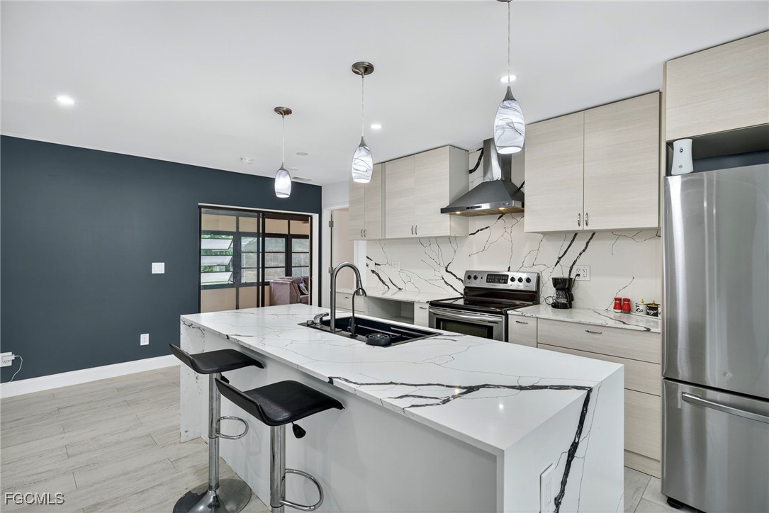 1672 Many Road North Fort Myers, FL 33903 - Photo 9 of 50 a kitchen with stainless steel appliances kitchen island a table and chairs in it
