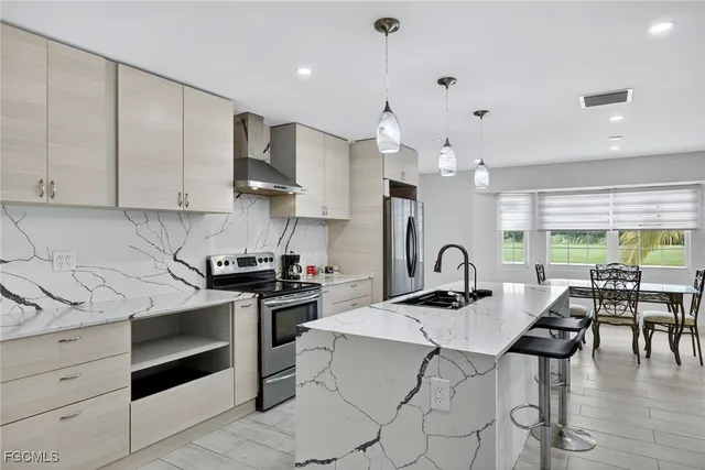 a kitchen with a stove a sink a kitchen island with a dining table and chairs