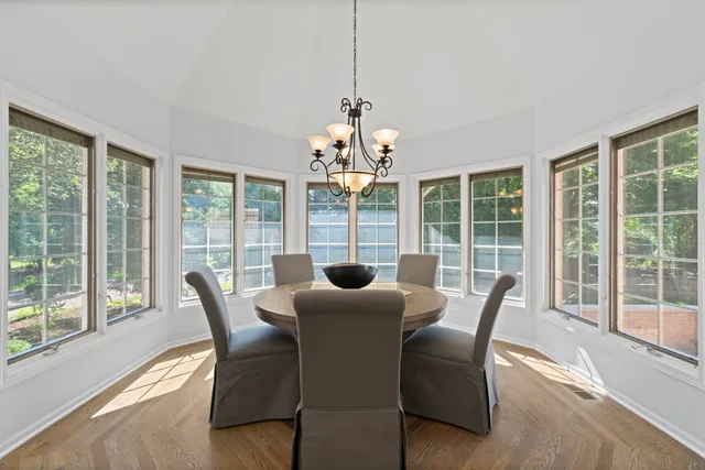 a dining room with furniture large windows and wooden floor