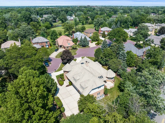 an aerial view of residential houses with outdoor space and trees all around