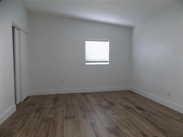 a view of a room with wooden floor and window