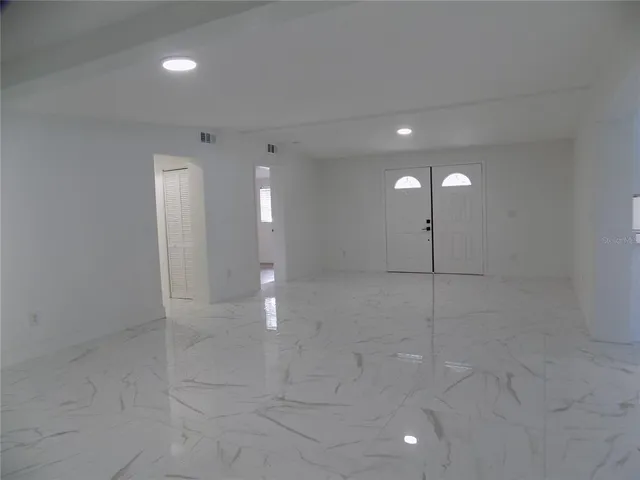 a view of a hallway with stairs and a chandelier fan