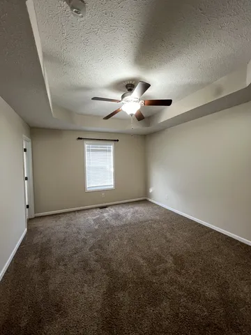 an empty room with a ceiling fan and window