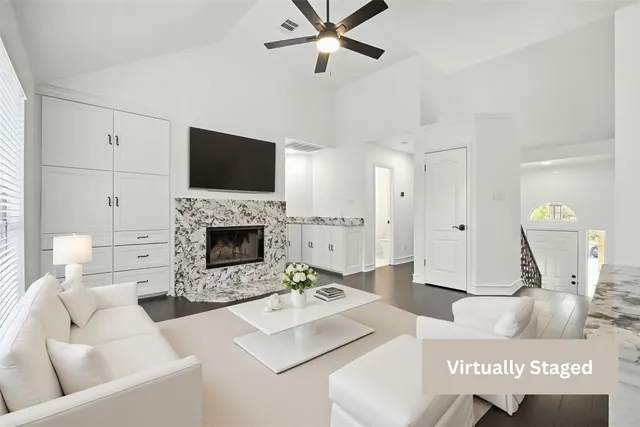a living room with furniture a flat screen tv and a fireplace
