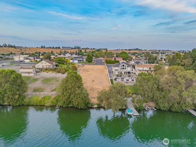 an aerial view of residential houses with outdoor space and lake