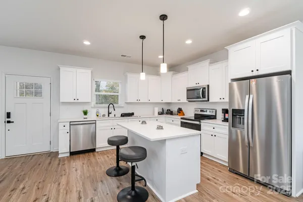 a kitchen with white cabinets and stainless steel appliances