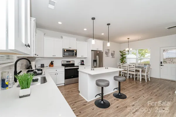 a kitchen with a dining table chairs sink and kitchen view