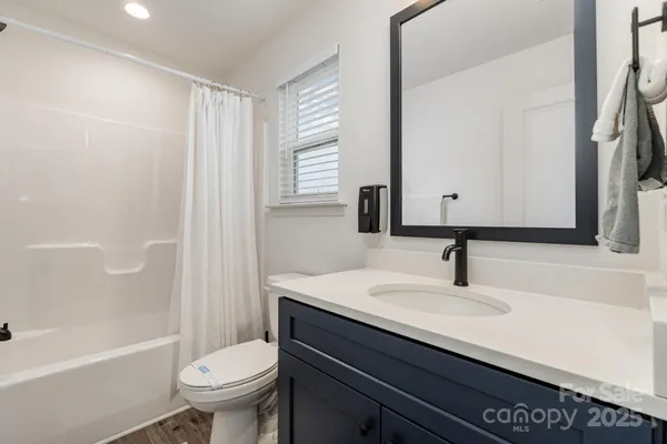 a bathroom with a sink toilet vanity and bathtub