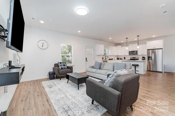 a living room with furniture wooden floor and a flat screen tv