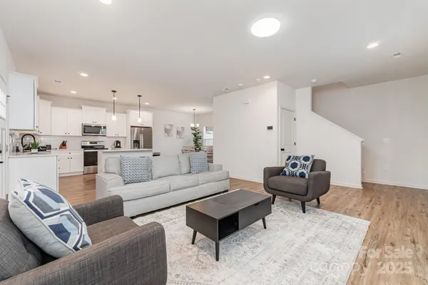 a living room with furniture and kitchen view