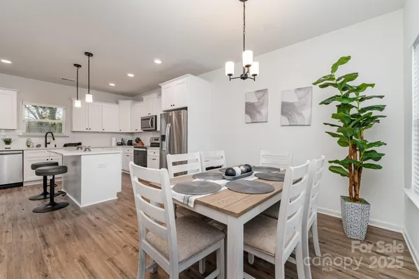a view of a dining room and livingroom with furniture wooden floor a chandelier