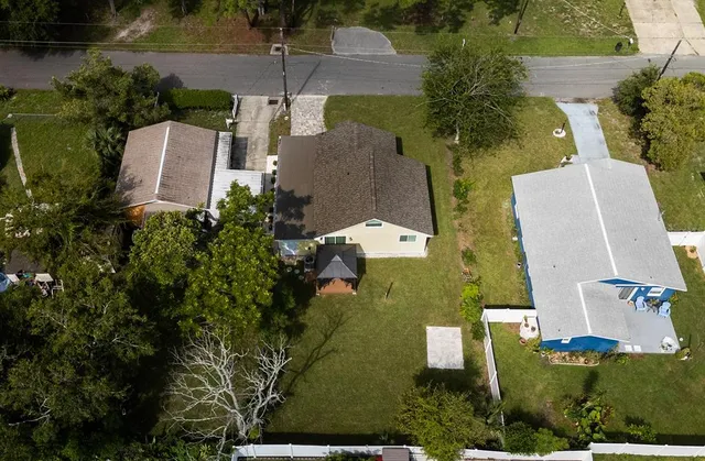 an aerial view of a house with a yard and lake view