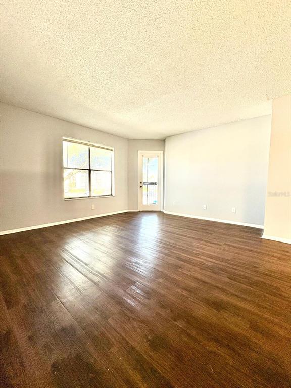 2102 Cascades Boulevard, Unit 205 Kissimmee, FL 34741 - Photo 2 of 12 an empty room with wooden floor and windows