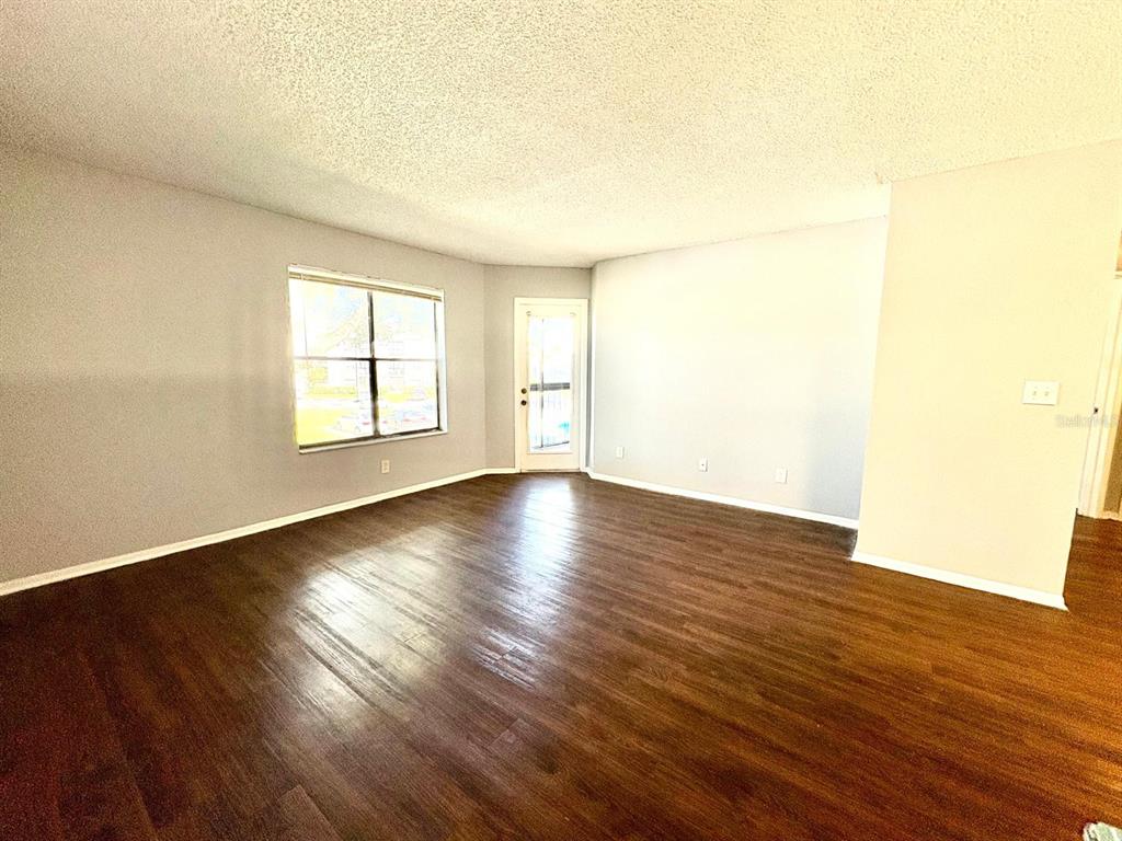 2102 Cascades Boulevard, Unit 205 Kissimmee, FL 34741 - Photo 3 of 12 an empty room with wooden floor and windows