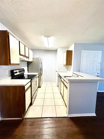 a large kitchen with stainless steel appliances granite countertop a stove a sink and a microwave