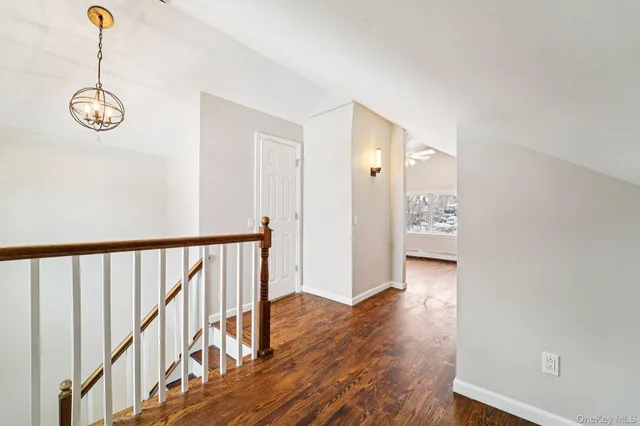 a view of a room with wooden floor and a chandelier