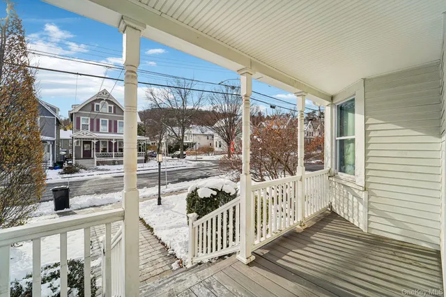 a front view of a house with a yard covered with snow