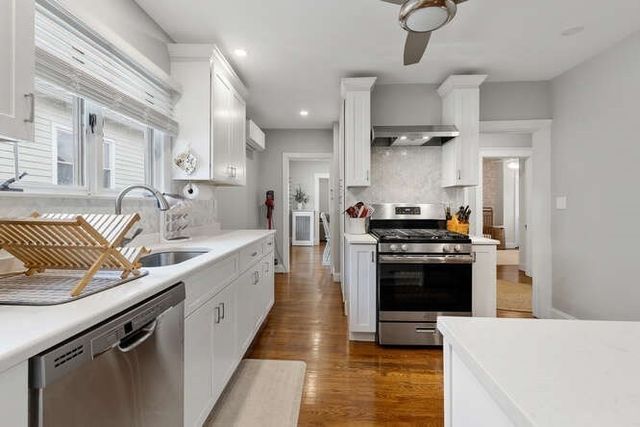 a large kitchen with stainless steel appliances granite countertop a stove and a sink