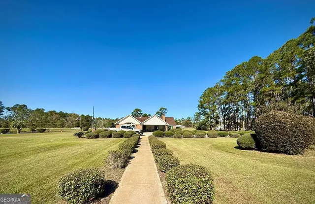 a kitchen with stainless steel appliances granite countertop a stove top oven a sink dishwasher a dining table and chairs with wooden floor