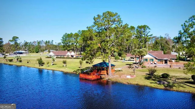 a view of swimming pool with outdoor seating and trees in the background