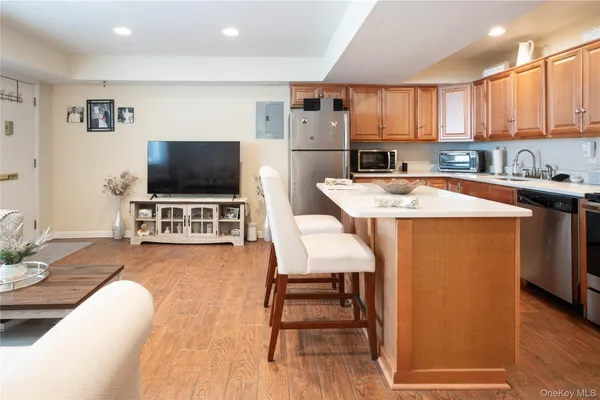 a kitchen with stainless steel appliances wooden floor dining table and chairs