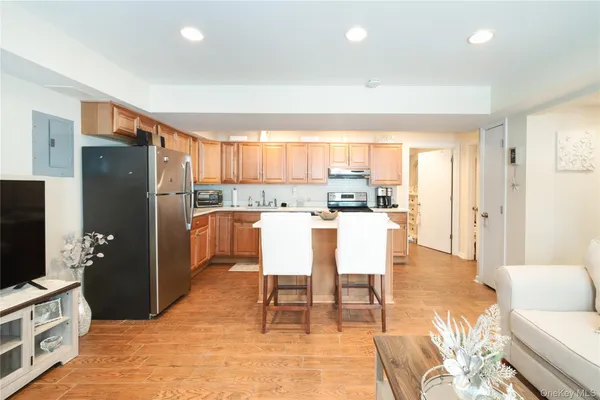 a dining room with stainless steel appliances a dining table chairs refrigerator and a sink