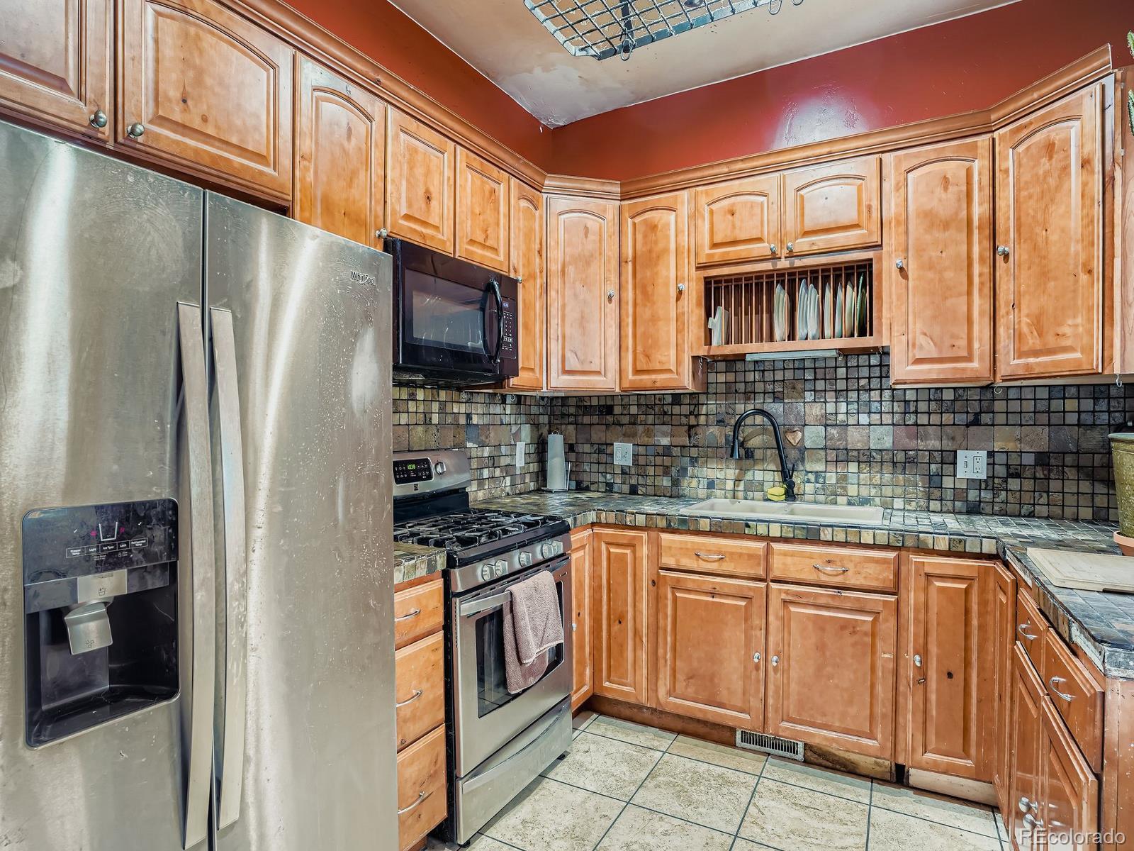 2516 North Marion Street Denver, CO 80205 - Photo 22 of 31 a kitchen with stainless steel appliances granite countertop a refrigerator and a stove top oven