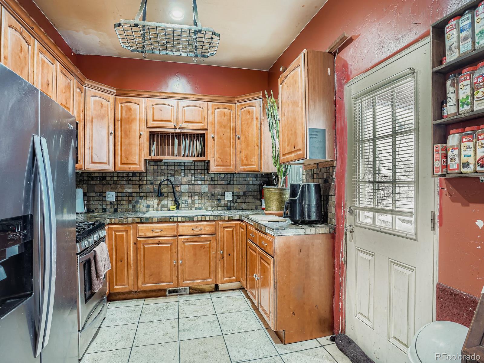 2516 North Marion Street Denver, CO 80205 - Photo 3 of 31 a kitchen with stainless steel appliances granite countertop a refrigerator a sink dishwasher a stove a dining table and chairs with wooden floor