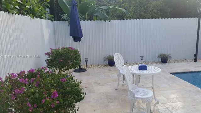 a view of an outdoor dining space with a table and chairs