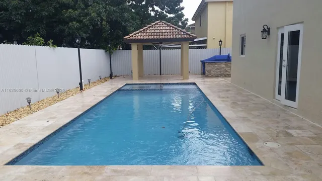 a view of a kitchen with kitchen island a sink wooden floor and a fireplace